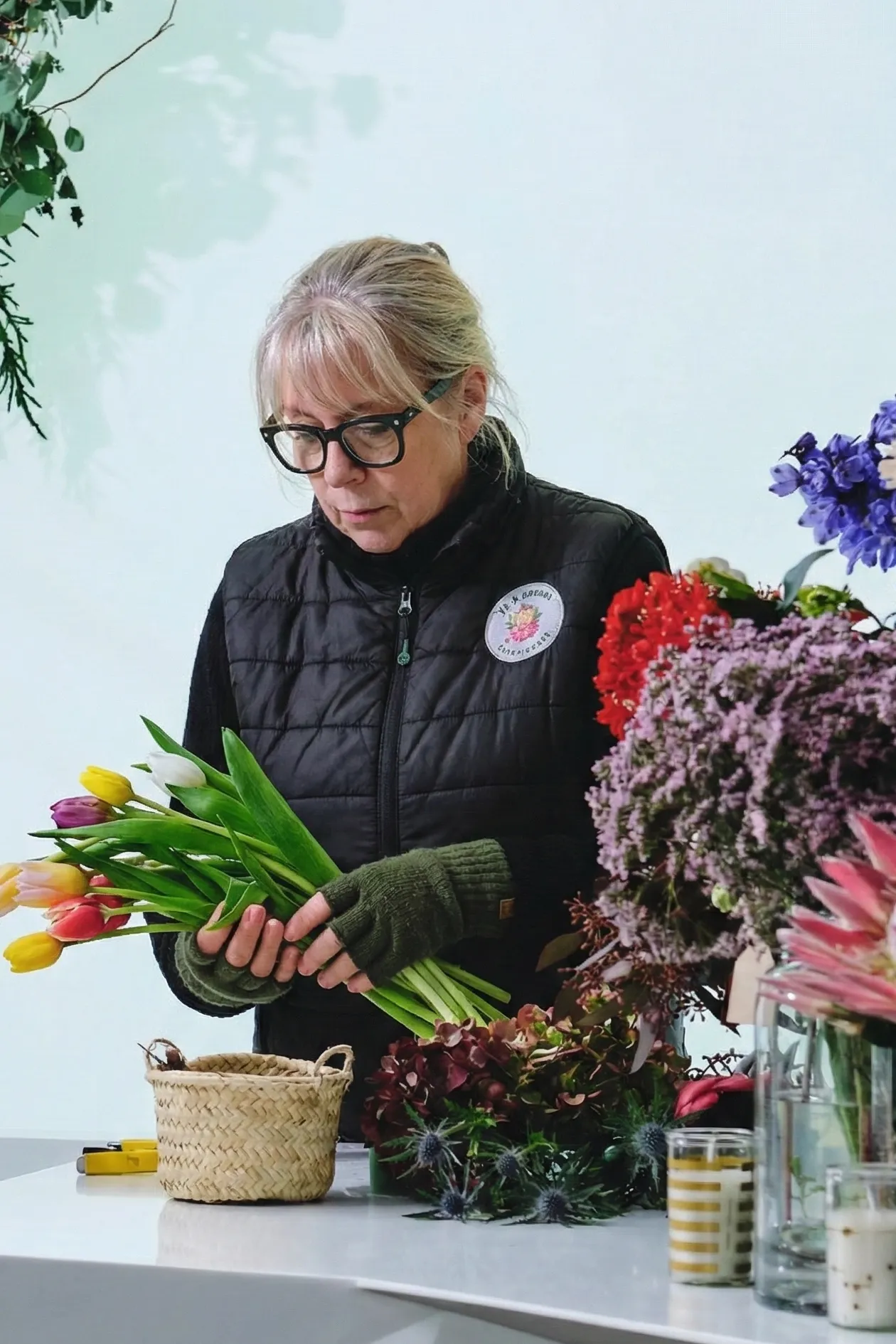 Woman holding tulips and preparing a floral arrangement